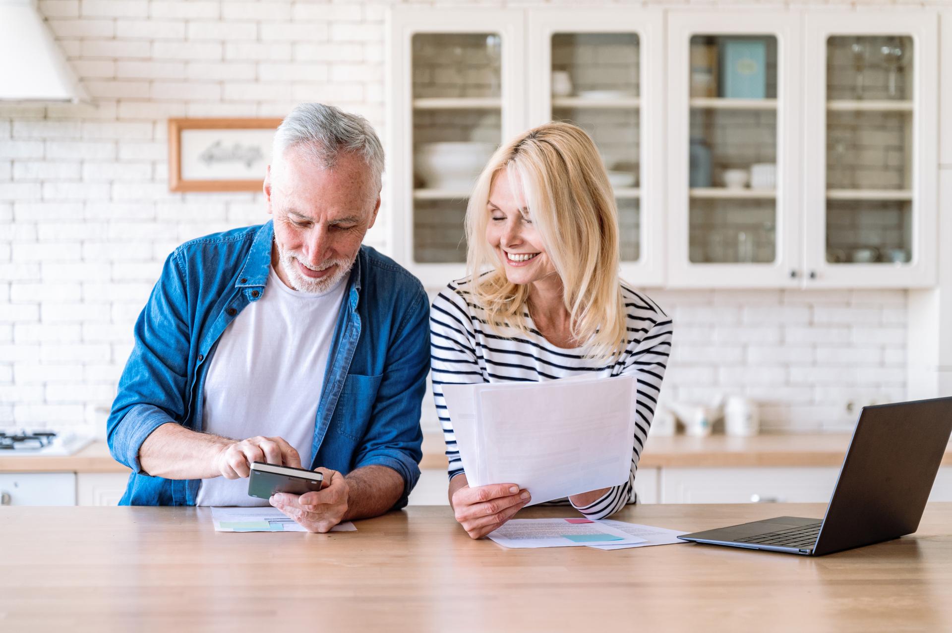 Happy mature family couple managing household budget together