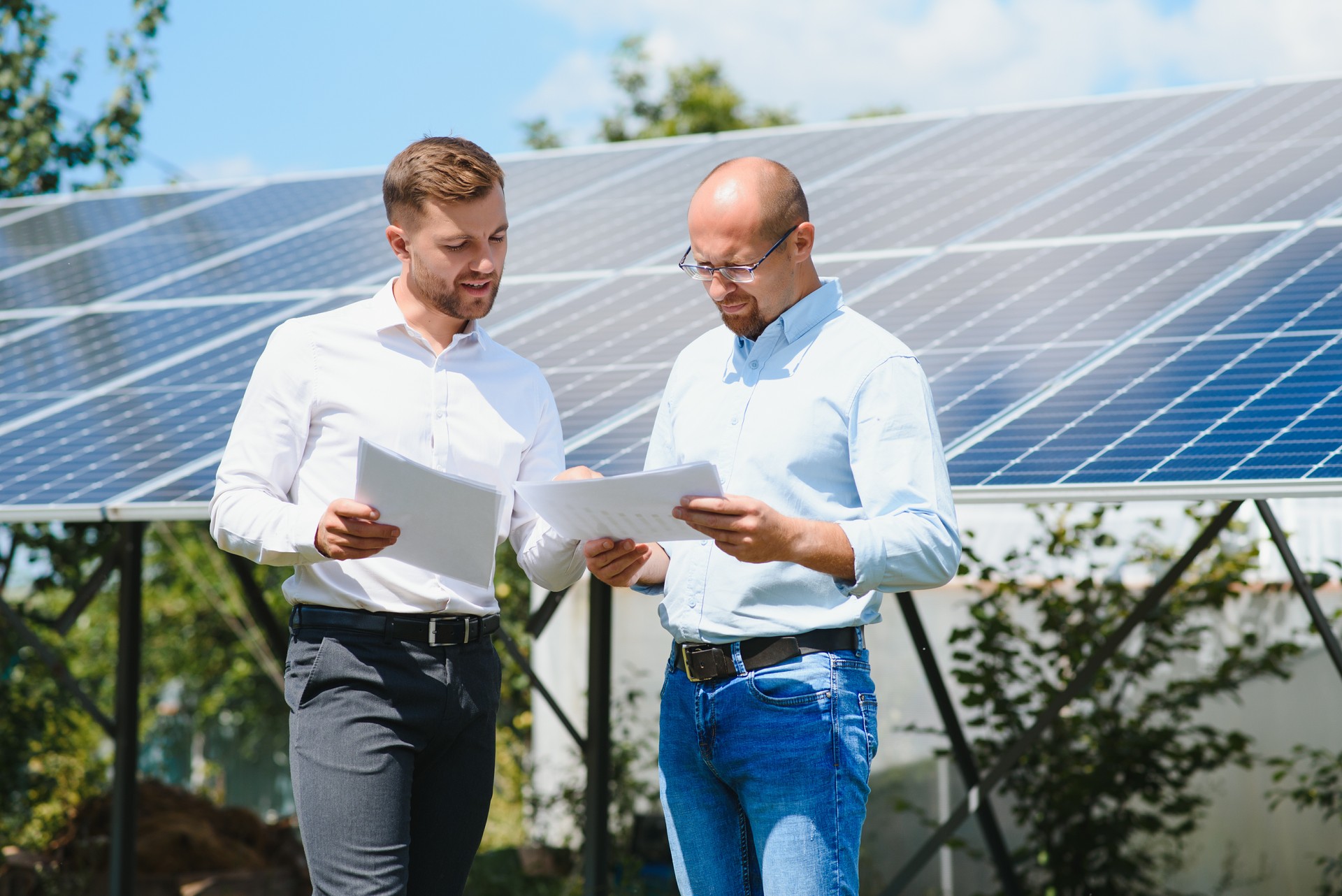 Two people having a shaking hands against solar panel after the conclusion of the agreement in the renewable energy