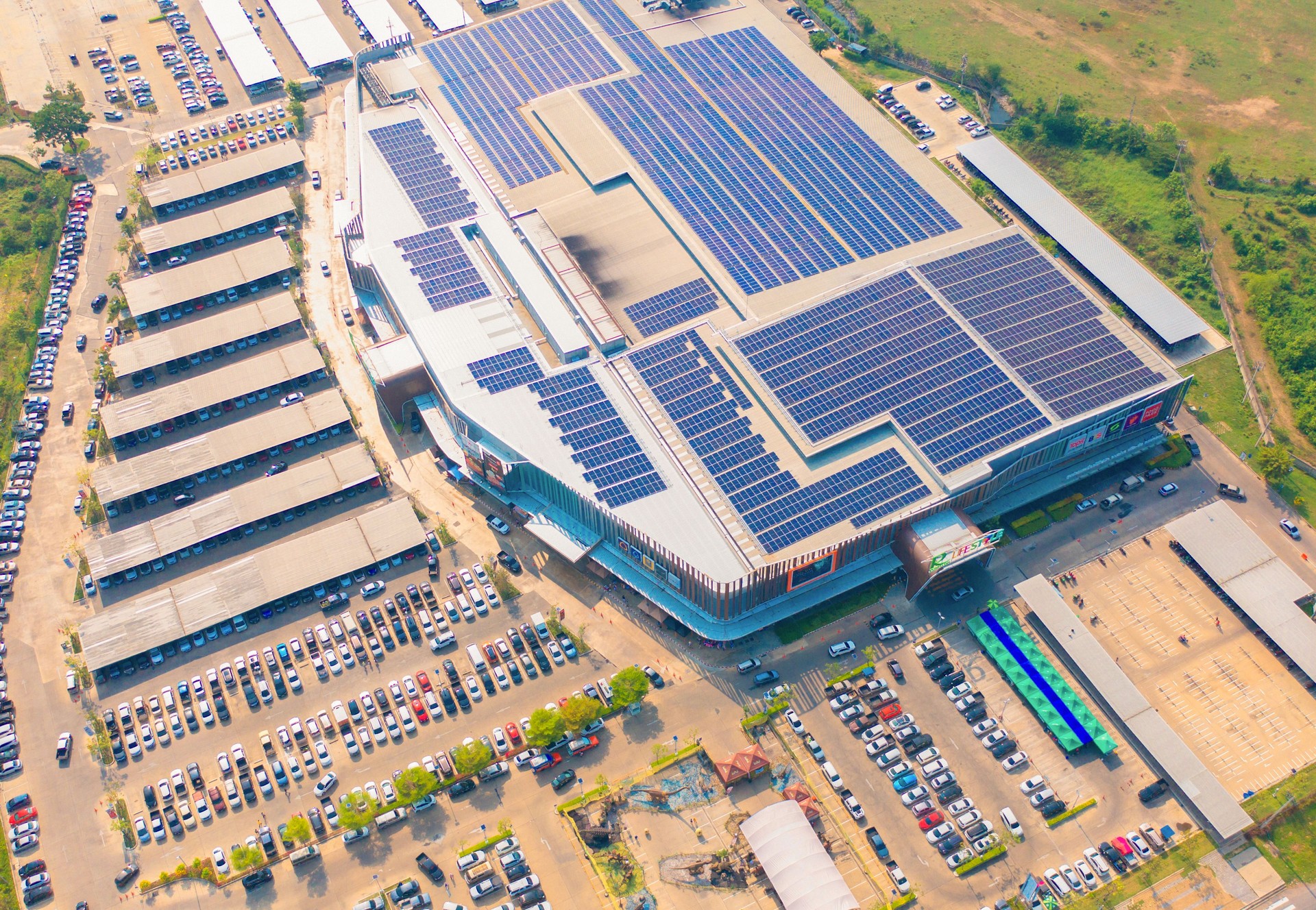 Aerial view of solar panels or solar cells on the roof of shopping mall building rooftop. Power plant, renewable clean energy source. Eco technology for electric power in industry.